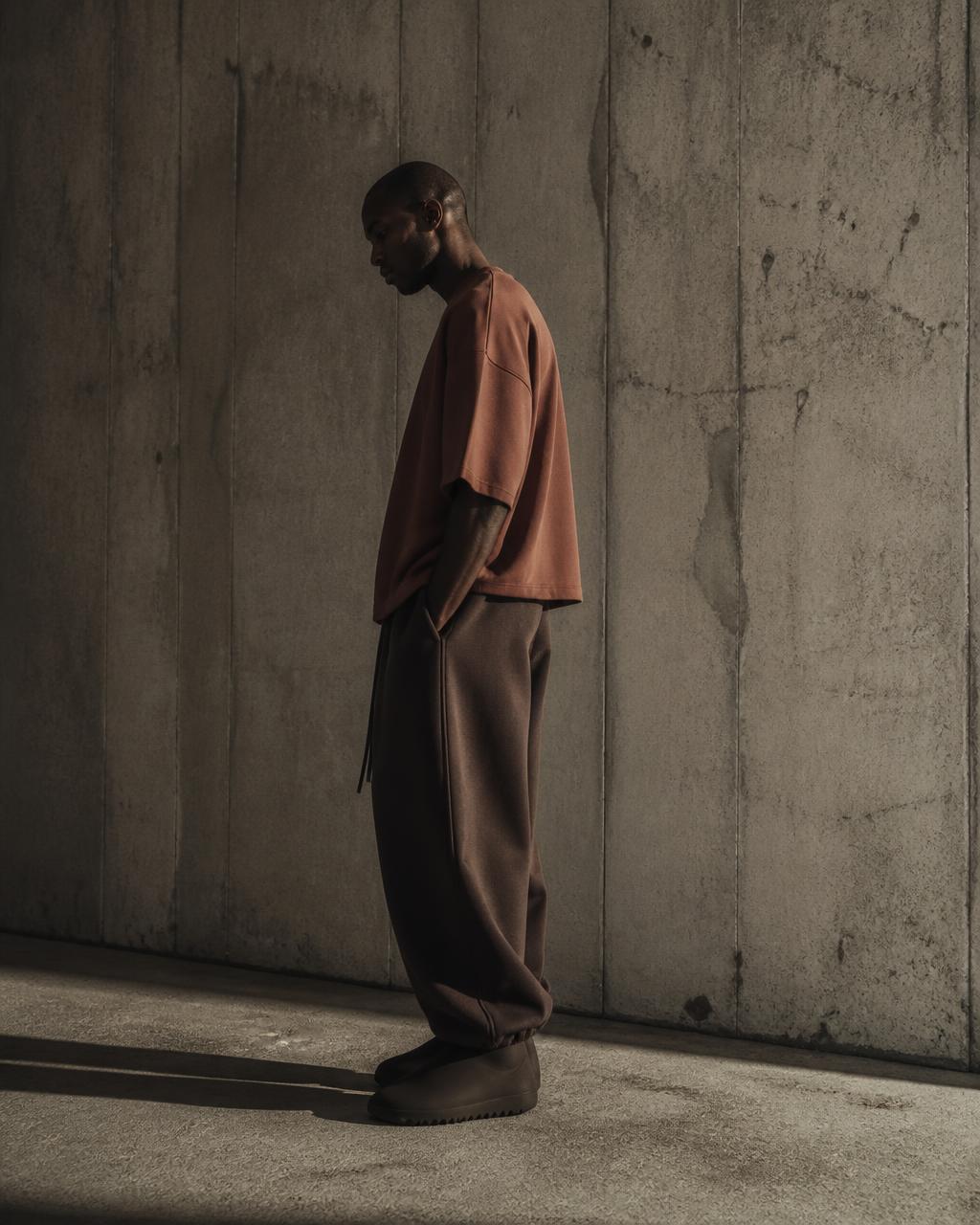 Heavyweight t-shirt in clay terracotta against a raw concrete wall